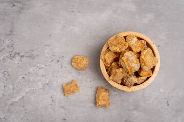 Pork rind. Crispy pork rinds are made from fine pork skin in a wooden bowl on a cement table.