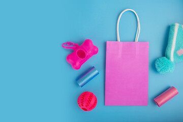 pet shop sale, pet accessories in a shopping bag on a blue background, top view, flat lay, copy space