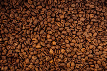 Closeup top view textured background full frame heap of brown roasted aromatic delicious coffee grains