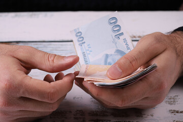 Young man counting Turkish banknotes in his hand. Turkish Lira TRY or TL