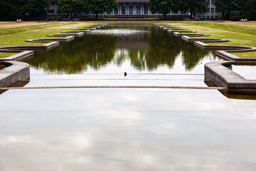 Naklejka premium Reflections in water in artificial lake in park