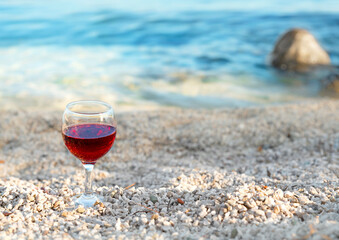 One glass of red wine on the beach in Budva