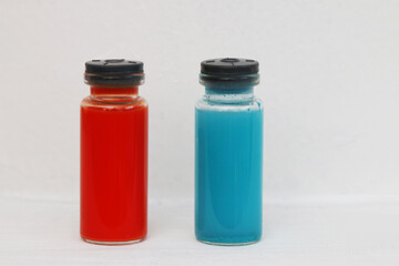 Two ampoules with chemical reagents on a white background.