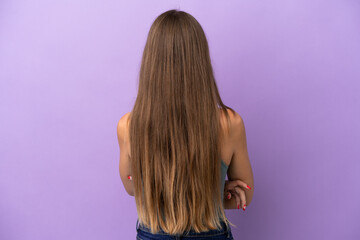 Fototapeta premium Young Lithuanian woman isolated on purple background in back position