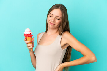 Young Lithuanian woman with cornet ice cream isolated on blue background suffering from backache for having made an effort