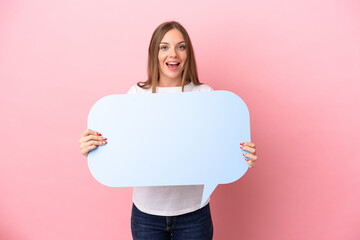 Young Lithuanian woman isolated on pink background holding an empty speech bubble with surprised expression