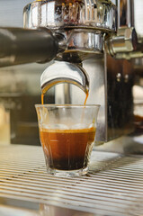 A coffee machine dispenses espresso coffee