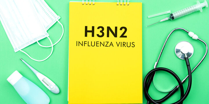 H3N2 influenza virus. Medical doctor kits with yellow notebook with word H3N2. Syringe, sanitizer, thermometer, mask, and stethoscope. Health and medical concept.