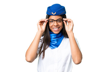 Airplane stewardess African american woman over isolated background with glasses and surprised