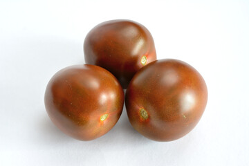 group of black tomatoes isolated on a white background, close-up 