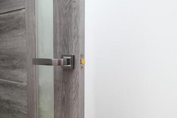 handyman repairing door lock in room, closeup. a repairman repairs the wooden interior door. handyman service.