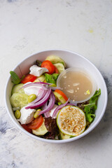 vegetable salad with cheese and sauce on a white background top view