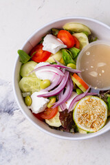vegetable salad with cheese and sauce on a white background top view