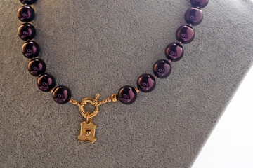 author beautiful  blackberry color pearls necklaces with heart pendant demonstrated on maneken. fashion and jewelry concept