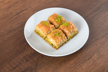 Turkish baklava with pistachio in plate.A plate baklava on wooden background,top view