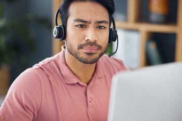Serious asian man, call center and computer with headphones for customer service, help or support...