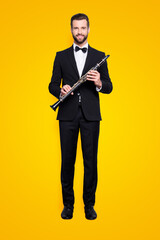 Full size, fullbody portrait of stylish, talented, cheerful musician with hairstyle in black tux...
