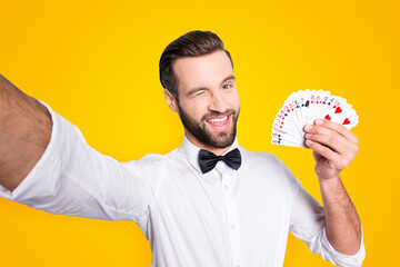 Self portrait of playful flirting croupier shooting selfie on front camera winking with eye...
