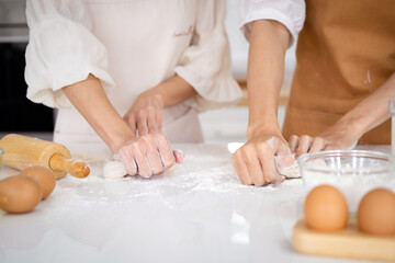 Obraz na płótnie Canvas hands of the baker's female knead dough . Close up view of bakers are working. Homemade bread. Hands preparing dough on table for homemade pastry and bread. Cooking and baking at home concept.