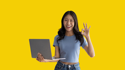 Asian woman in casual clothes holding working laptop in freelance work concept with single laptop can earn money, Invitation to apply or register to receive special privileges and prizes. - obrazy, fototapety, plakaty