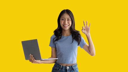 Asian woman in casual clothes holding working laptop in freelance work concept with single laptop can earn money, Invitation to apply or register to receive special privileges and prizes. - obrazy, fototapety, plakaty