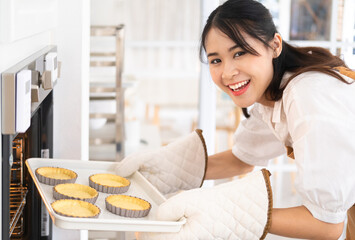 Baking At Home. Young Happy Lady Cooking tart In Kitchen, Smiling Beautiful Woman Wearing Apron And...