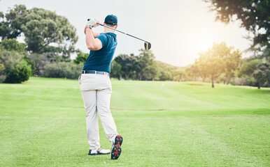Golf, back and hobby with a sports man swinging a club on a field or course for recreation and fun. Golfing, grass and stroke training with a male golfer playing a game on a green during summer - Powered by Adobe