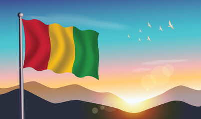 Guinea flag with mountains and morning sun in background