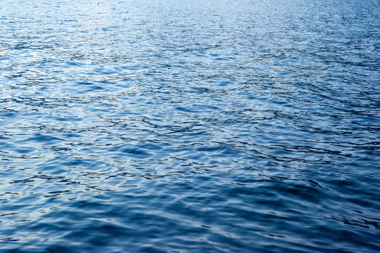 Background from sea water with small ripple waves, close-up. Blue sea texture for publication, design, poster, calendar, post, screensaver, wallpaper, postcard, banner, cover. High quality photo