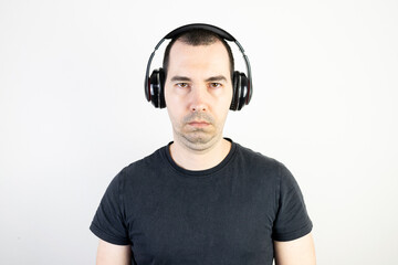 young man male guy model wearing headphones cool fashion style looks unhappy angry stand wear bad music sound listening
