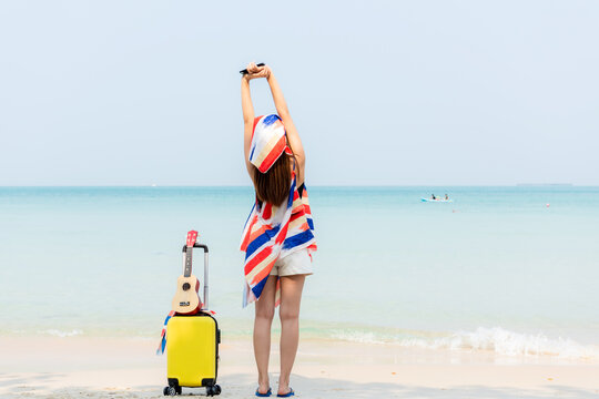 Summer vacations. Lifestyle  woman relax and chill on beach background.  Asia happy young people with bag travel suitcase luggage fashion dress raise arm wave sea, summer trips travel