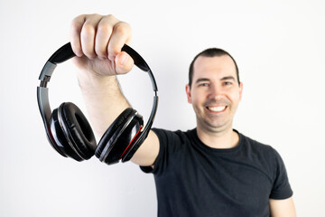 young man male guy model hold headphones cool fashion style looks happy stand enjoy music good sound relax smile