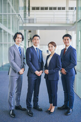 オフィスの廊下に並んで立つビジネスマンの男女