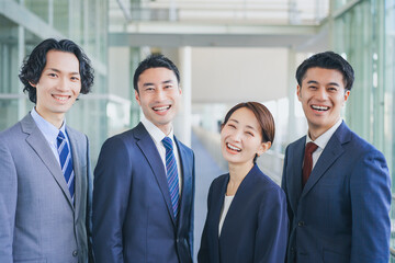 オフィスの廊下に並んで立つビジネスマンの男女