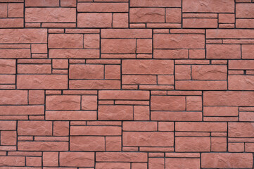 Decorative stone in the form of a sharp bumpy red tile.