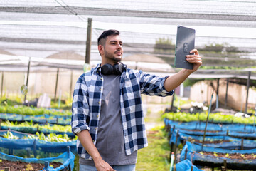 Farmer using digital tablet in the vegetable farm organic smart farm control by science technology