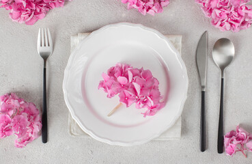 Fototapeta na wymiar Elegance Easter table setting with pink hydrangea flowers and eggs on gray background, Flat lay
