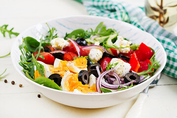 Breakfast. Greek salad and boiled eggs.  Fresh vegetable salad with tomato,  cucumbers, olives, arugula and cream cheese. Trendy food.