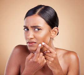 Indian woman, pimple and skincare in studio for treatment, cosmetics and worried by background....