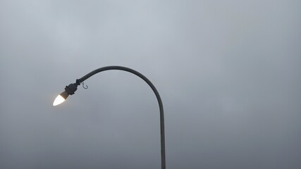 Single lightstreet under the gray clear sky at the afternoon