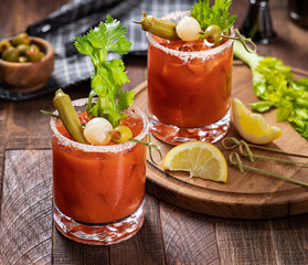 Bloody mary cocktail with garnishes on rustic wooden table © chas53