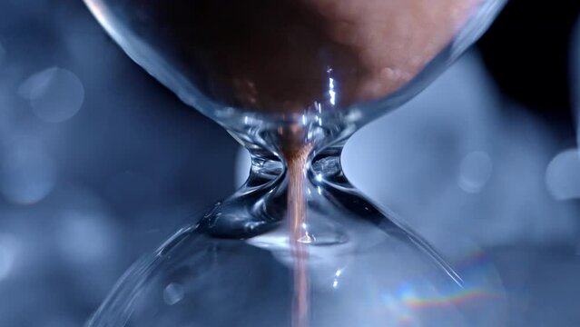 Blue light hourglass with sand falling