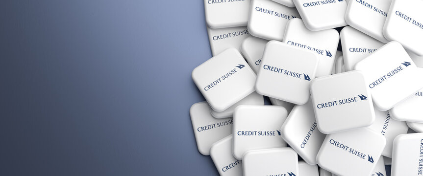 Logos of Credit Suisse Bank on a heap on a table. Copy space. Web banner format.