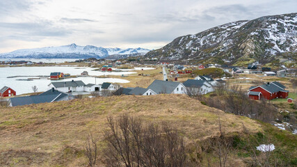 Fototapeta na wymiar schöne, bunte Häuser am Ufer des Nordatlantik. hölzerne Ferienhäuser auf den Inseln Hillesøy und Sommarøy. rotes Haus am See. Ferien in Troms, Nordnorwegen, Norwegen