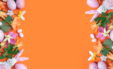 easter frame with fresh spring carrots ,easter eggs,confetti,decor on an orange background. top view. copy space. flat lay.