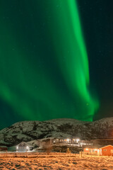 wundervolle Nordlichter über dem Dorf Hillesøy in Troms. begeisterndes Lichtspiel am nächtlichen Himmel, Aurora Borealis über der Insel am Nordatlantik