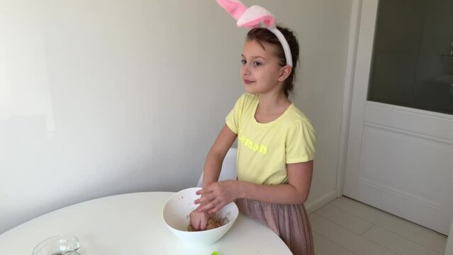 baking Easter gingerbread cookies. little happy girl bakes cookies for easter. the concept of preparing for easter, happy easter