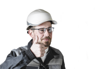 Positive friendly bearded male builder in overalls, hardhat and goggles showing thumbs up. Isolated background.