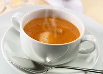 Sopa de pescado caliente en cuenco con cuchara. Hot fish soup in bowl with spoon.