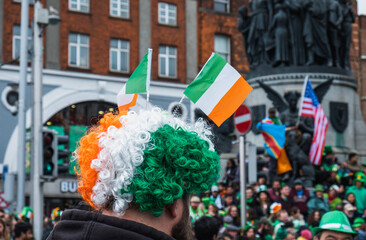 Person with irish flag coloured wig and flag headband, o'Connel street Dublin, during the Saint...